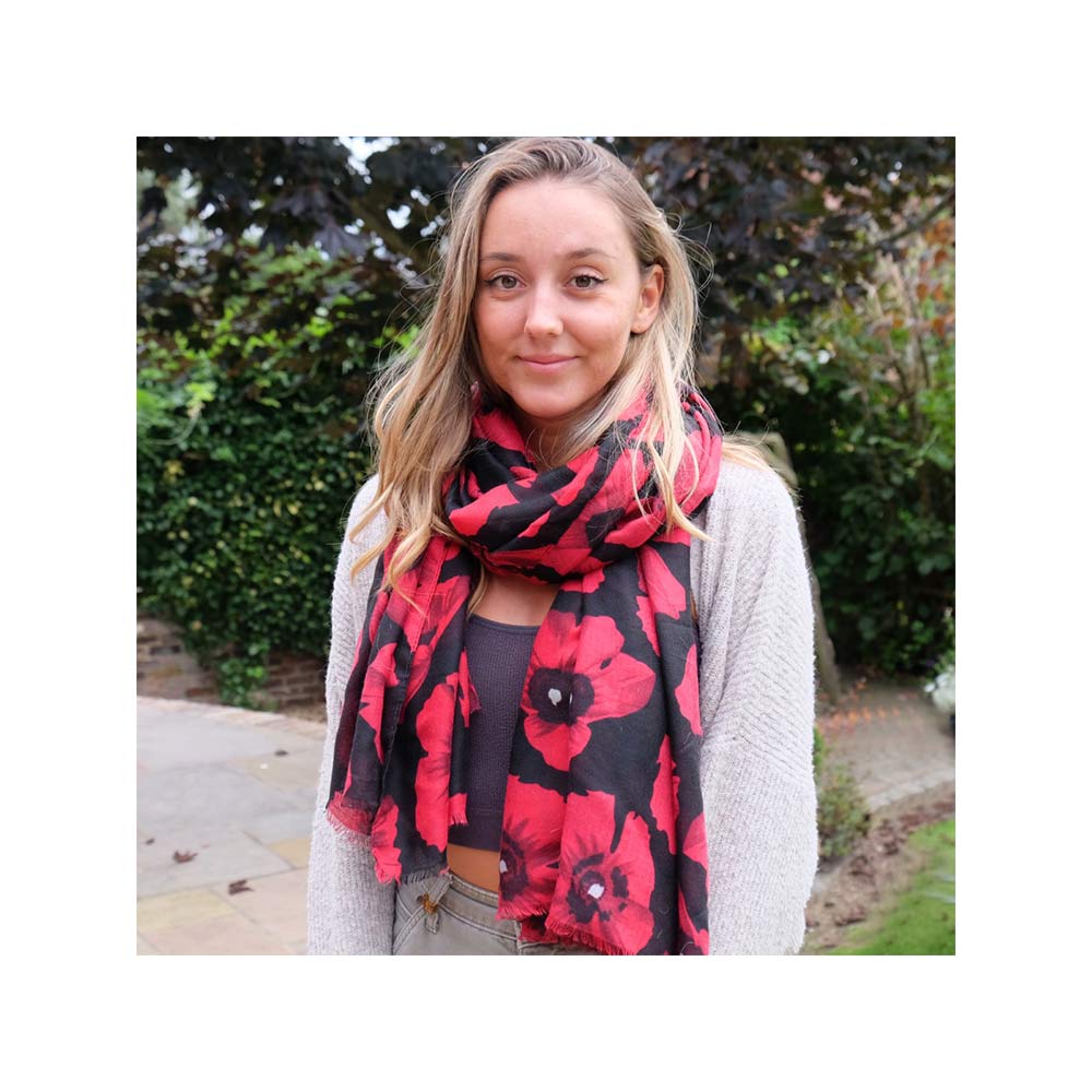 A woman with a red and black Poppy scarf draped around her neck captures the essence of nature.
