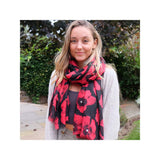 A woman with a red and black Poppy scarf draped around her neck captures the essence of nature.