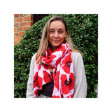A woman with a red and white Poppy scarf draped around her neck captures the essence of nature.