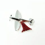 This brooch features the iconic Spitfire aircraft performing a “Drop” of red poppies.