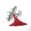 A silver tone brooch features the iconic Lancaster Bomber performing a “Drop” of cascading red poppies