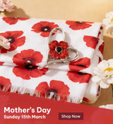 Heart-shaped brooch with red gem on a poppy-patterned fabric, Mother's Day promotion text.