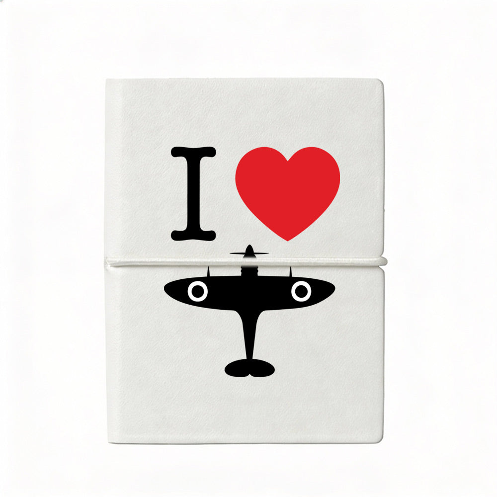 Compact A7 white notebook with soft cover featuring ‘I Love Spitfire’ design, plain coloured pages, and elastic strap, made exclusively for the Royal Air Force Museum.