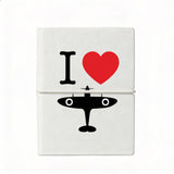 Compact A7 white notebook with soft cover featuring ‘I Love Spitfire’ design, plain coloured pages, and elastic strap, made exclusively for the Royal Air Force Museum.